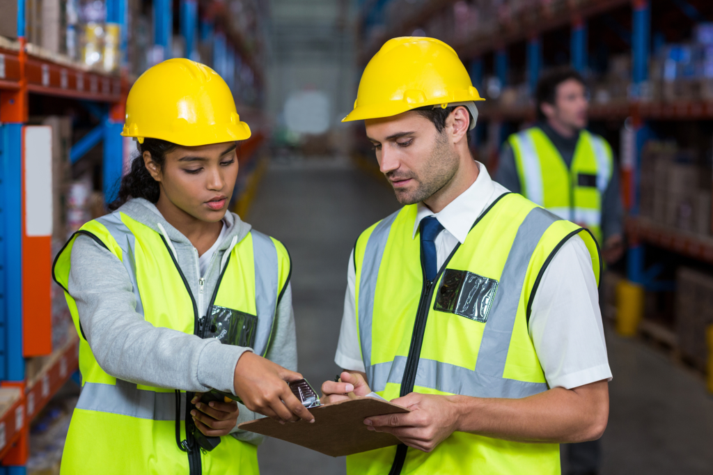 Workers in a warehouse looking at a clipboard